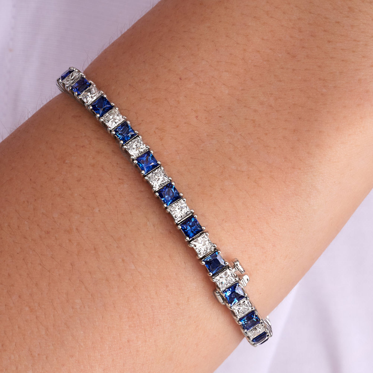 11.26 CT Alternating Princess Cut Blue Sapphire and Diamond Tennis Bracelet in 14K White Gold, worn on model, view 1 - fine jewelry in San Francisco